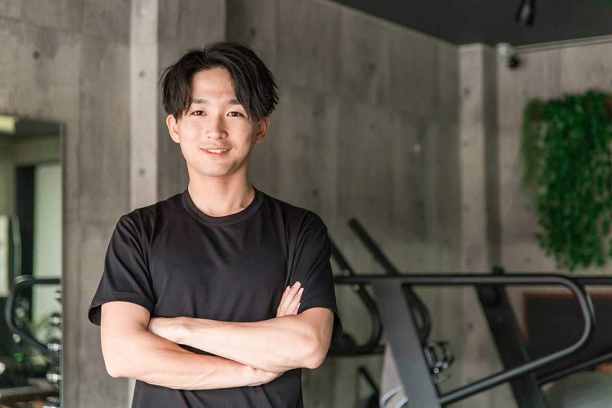 腕組みをしながら笑顔で微笑む男性